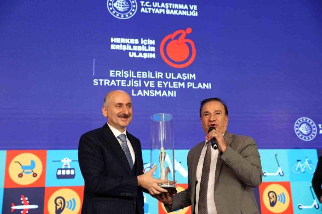 Ulaştırma Bakanı Adil Karaismailoğlu Türkiye Sakatlar Konfederasyou başkaımız Yusuf Çelebiye Plaket hediye ediyor.