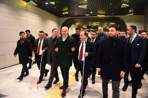 Ulaştırma ve Altyapı Bakanı Adil Karaismailoğlu'nun koluna Türkiye Sakatlar Konfederasyonu Başkanı Yusuf Çelebi ve diğer engelli bireyler girmişler, birlikte yürüyorlar.